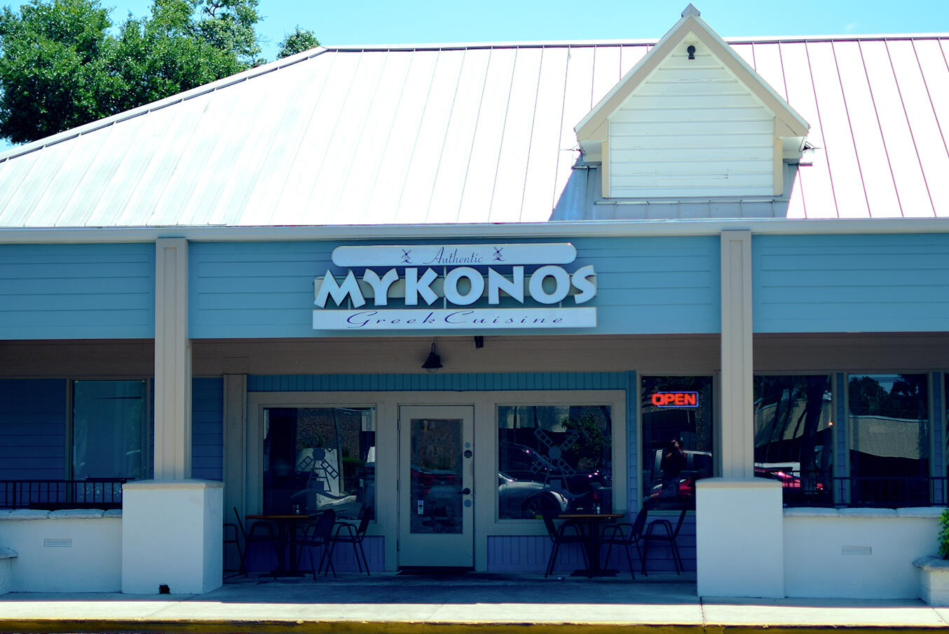 Photo of Mykonos Longwood Outside Photo of Mykonos Authentic Greek Cuisine in Longwood, FL from the outside showing the sign and outdoor seating